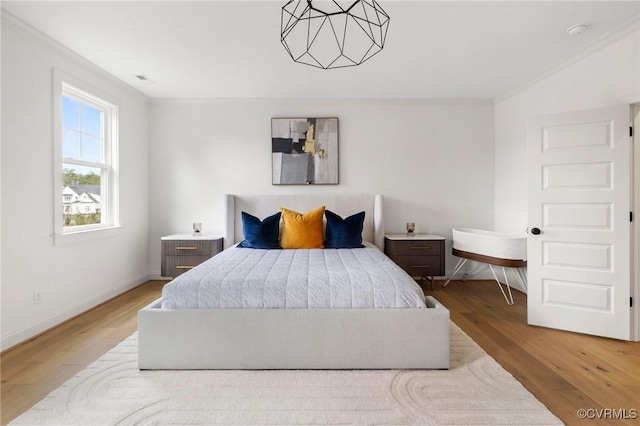 bedroom featuring crown molding, baseboards, and wood finished floors