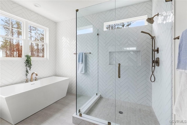 bathroom with a soaking tub and a stall shower