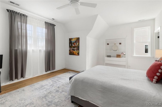 bedroom featuring lofted ceiling, ceiling fan, wood finished floors, and visible vents