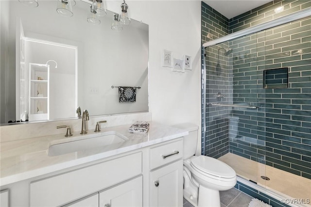 full bath with a stall shower, tile patterned flooring, vanity, and toilet