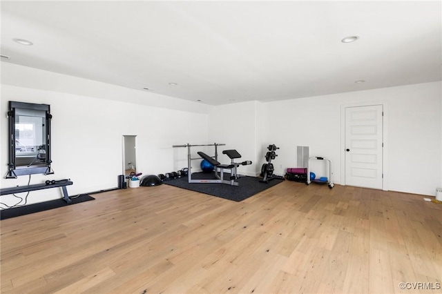 workout area with light wood-style floors and recessed lighting