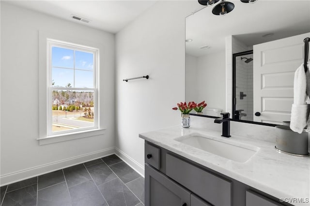 full bath with baseboards, visible vents, a tile shower, and vanity