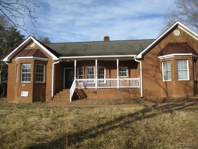 ranch-style house featuring a porch, crawl space, a chimney, and brick siding