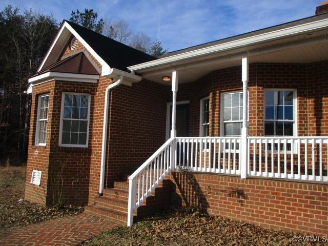 exterior space featuring covered porch and brick siding