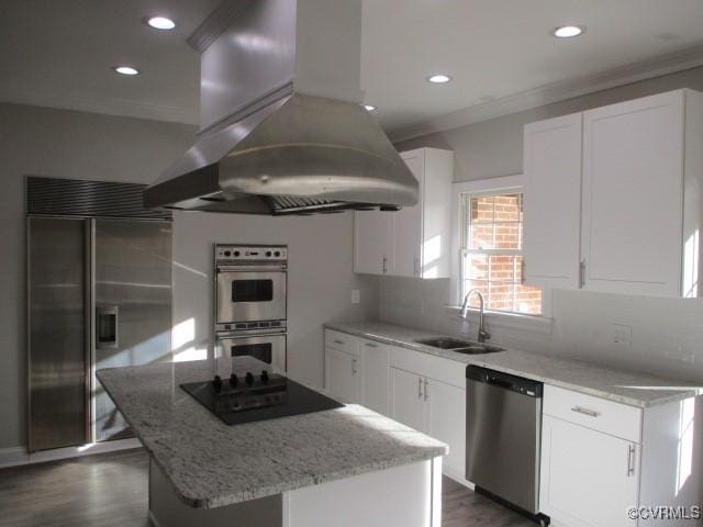 kitchen featuring island range hood, stainless steel appliances, a kitchen island, a sink, and white cabinetry