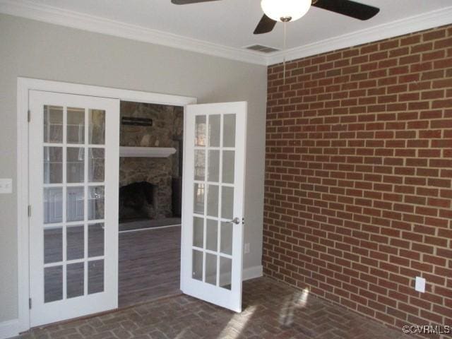 interior space featuring brick floor, brick wall, and crown molding