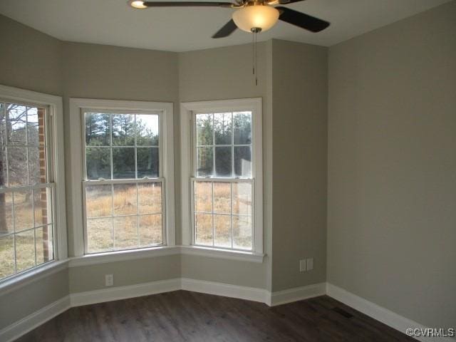 interior space featuring dark wood-style floors, ceiling fan, and baseboards