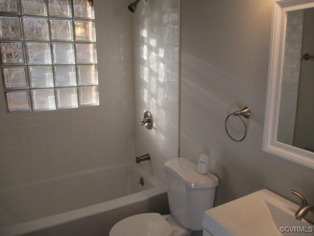 bathroom featuring vanity, shower / tub combination, and toilet