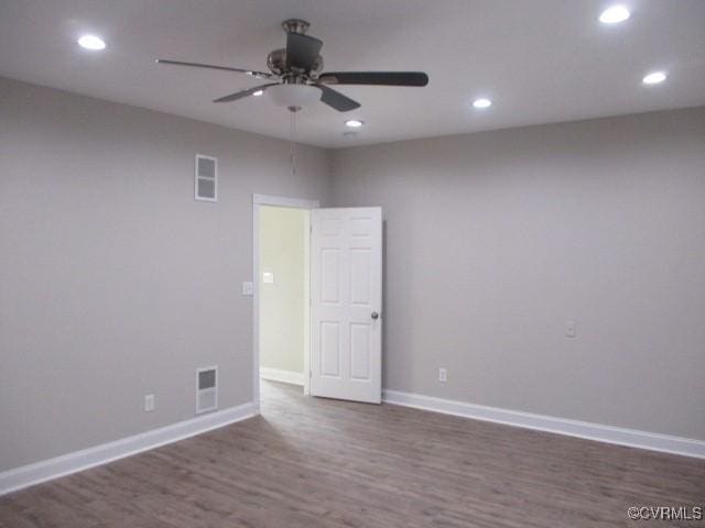 spare room with recessed lighting, wood finished floors, visible vents, and baseboards