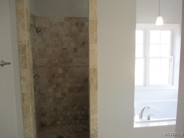 bathroom with a tile shower and a bath