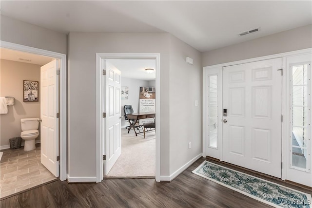 foyer with visible vents, dark wood finished floors, and baseboards