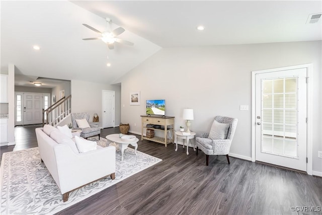 living area featuring lofted ceiling, visible vents, dark wood-type flooring, baseboards, and stairs