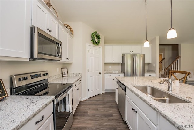 kitchen featuring dark wood-style flooring, a sink, white cabinetry, appliances with stainless steel finishes, and decorative light fixtures