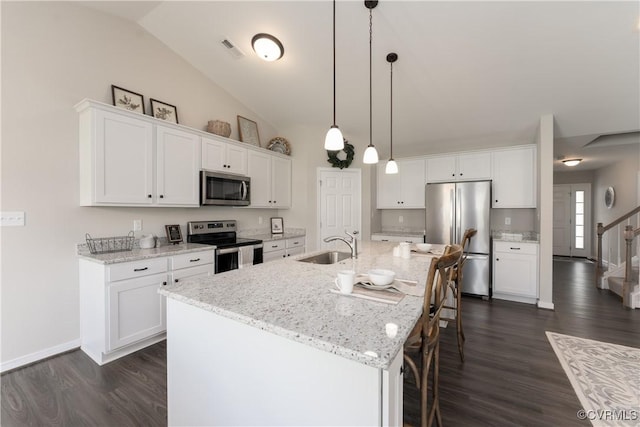 kitchen with white cabinetry, visible vents, appliances with stainless steel finishes, and a breakfast bar