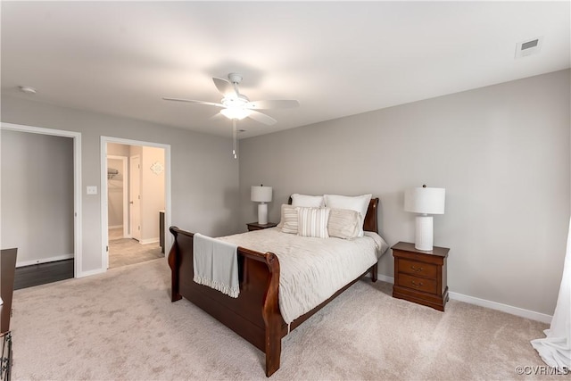 bedroom with light carpet, ceiling fan, visible vents, and baseboards