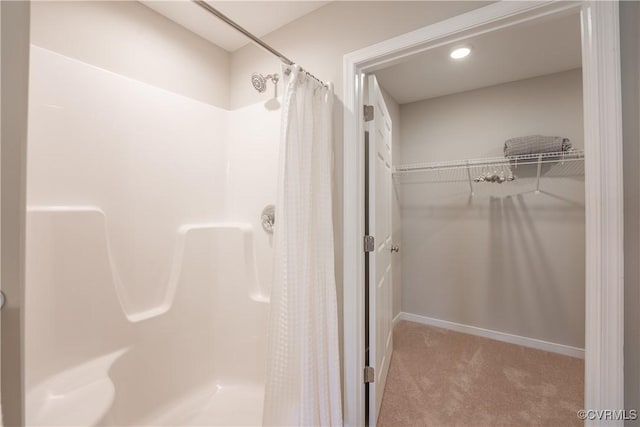 full bath with curtained shower and a walk in closet