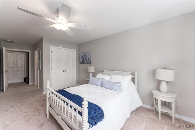 bedroom featuring ceiling fan, light carpet, visible vents, baseboards, and a closet