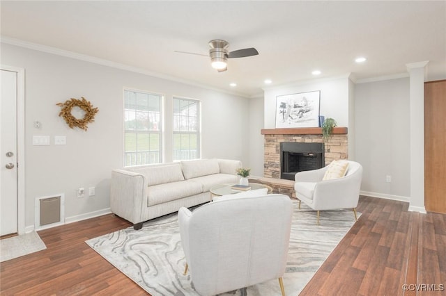 living room featuring baseboards, a fireplace, ornamental molding, and wood finished floors