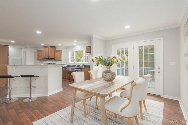 dining space with recessed lighting, crown molding, baseboards, and wood finished floors