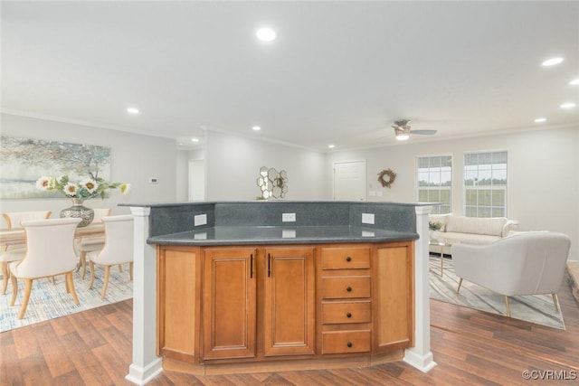 kitchen featuring a kitchen island, dark countertops, wood finished floors, and recessed lighting