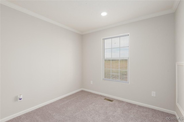 empty room featuring ornamental molding, carpet flooring, visible vents, and baseboards