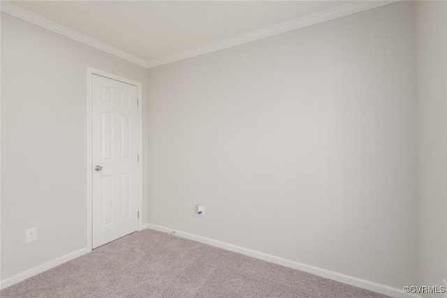 carpeted spare room featuring baseboards and crown molding