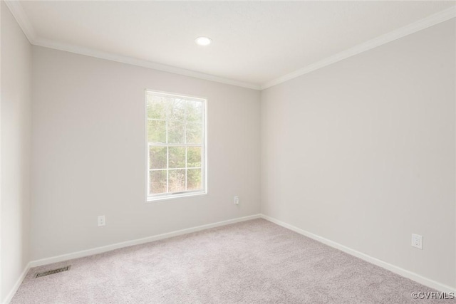 spare room featuring baseboards, crown molding, visible vents, and carpet flooring