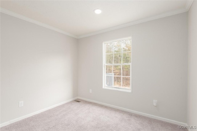 empty room with ornamental molding, a healthy amount of sunlight, light colored carpet, and baseboards