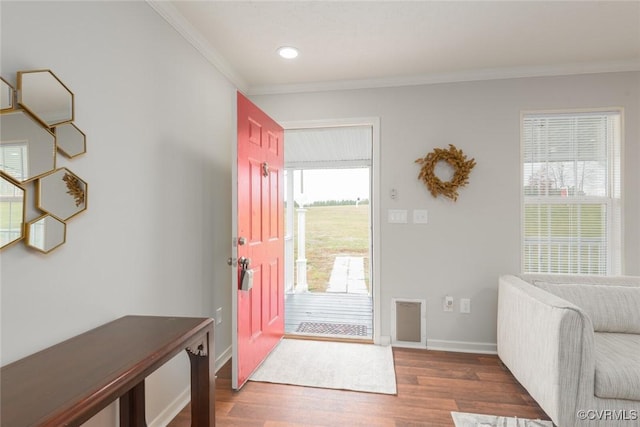 entryway featuring crown molding, visible vents, wood finished floors, baseboards, and stairs