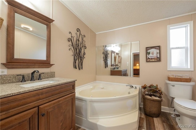 full bathroom with toilet, vanity, a whirlpool tub, wood finished floors, and a textured ceiling