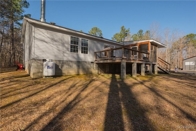 rear view of property featuring a yard, stairs, and a deck