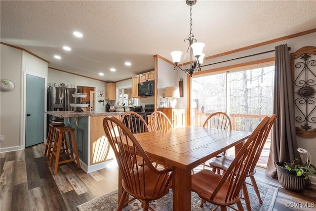 dining room featuring a textured ceiling, dark wood finished floors, and ornamental molding