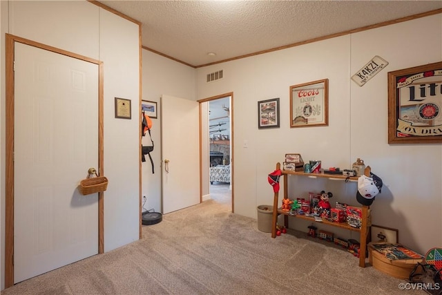 rec room featuring visible vents, a textured ceiling, ornamental molding, and carpet flooring