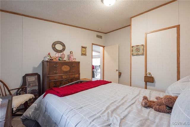 bedroom featuring visible vents, a textured ceiling, and crown molding