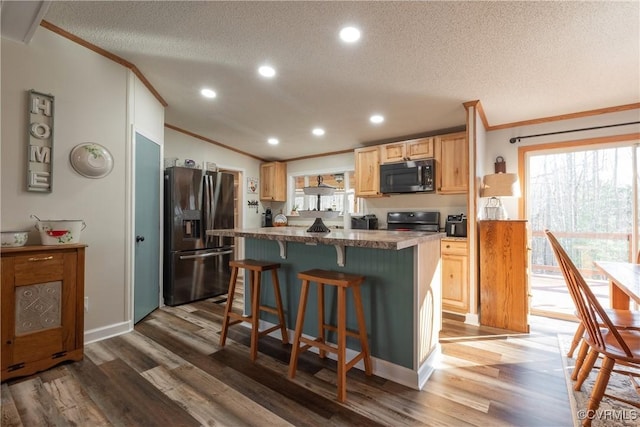 kitchen featuring stainless steel microwave, stove, black fridge, and crown molding