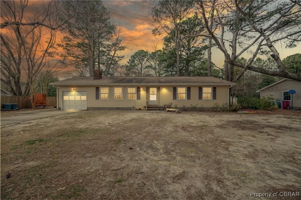 ranch-style house featuring a garage, driveway, entry steps, a chimney, and fence