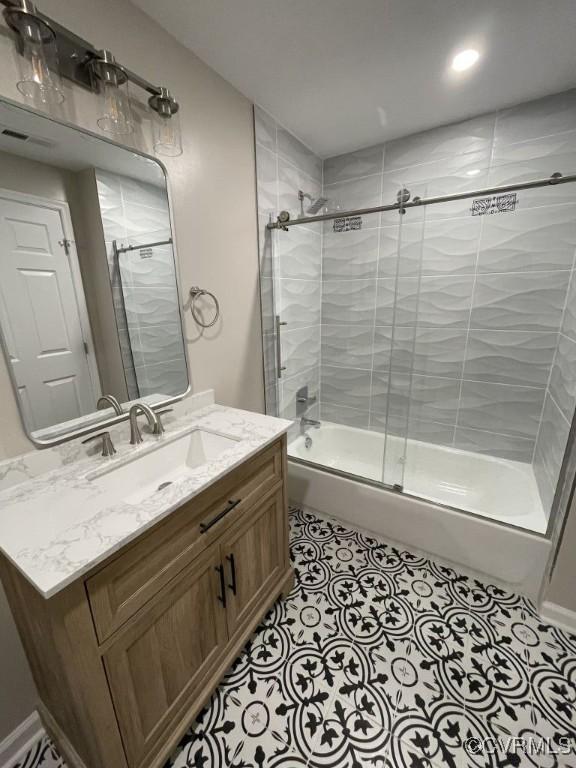 full bath with tile patterned flooring, enclosed tub / shower combo, and vanity