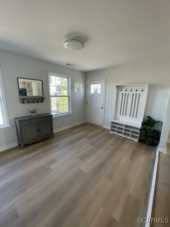 entryway with light wood finished floors, visible vents, and baseboards