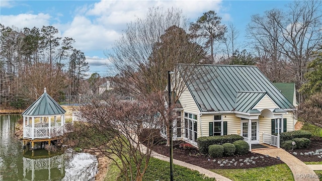 exterior space featuring a standing seam roof, french doors, a water view, and metal roof