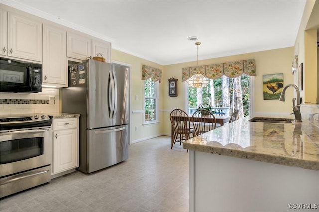 kitchen featuring decorative backsplash, light stone countertops, stainless steel appliances, and a sink