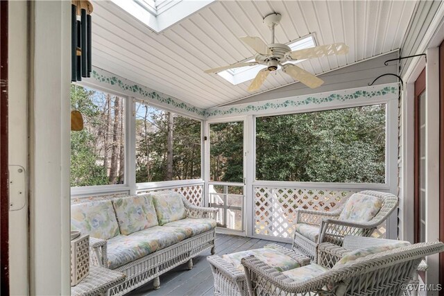 sunroom featuring wooden ceiling, vaulted ceiling with skylight, and ceiling fan