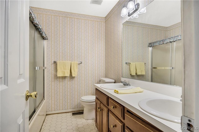 bathroom with a sink, visible vents, toilet, and wallpapered walls