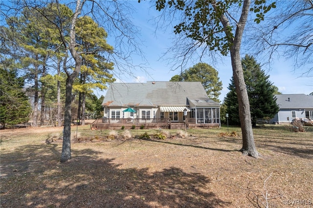 back of property featuring a sunroom and a deck