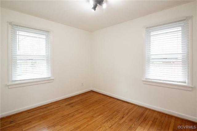 unfurnished room featuring baseboards and light wood finished floors