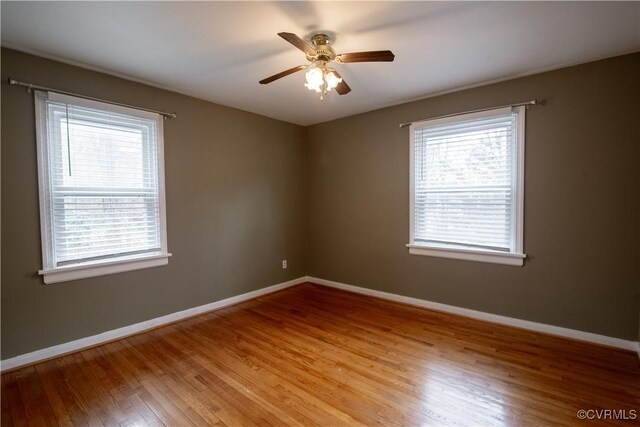 spare room with a wealth of natural light, baseboards, and light wood-style floors