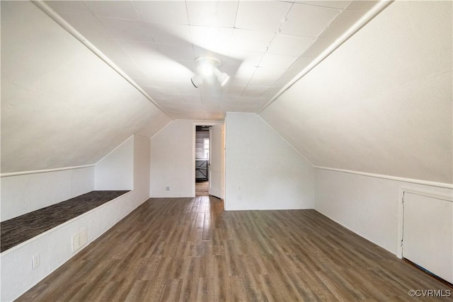 additional living space with visible vents, lofted ceiling, and wood finished floors