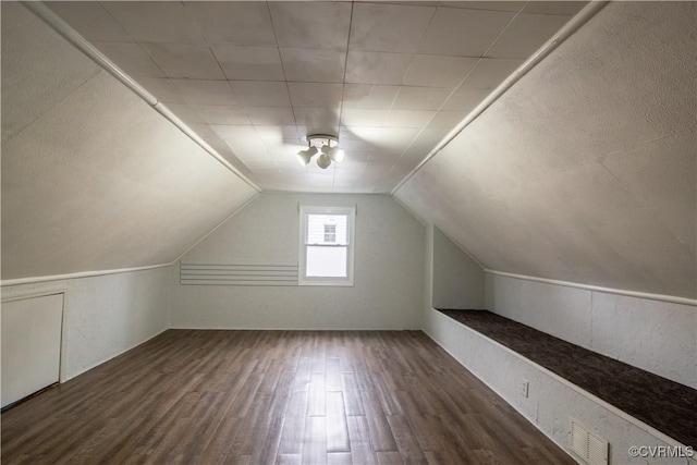 additional living space with lofted ceiling, wood finished floors, and visible vents