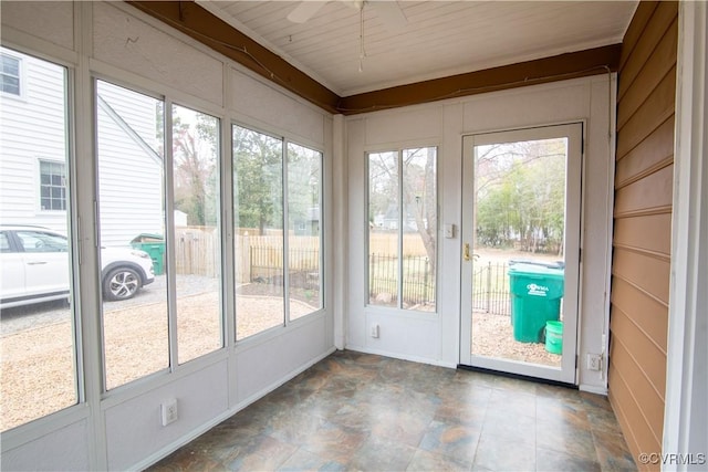 unfurnished sunroom with ceiling fan