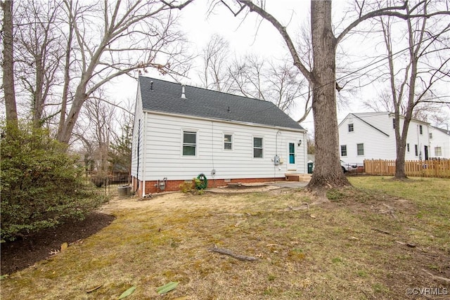 back of house with crawl space, a yard, fence, and a shingled roof