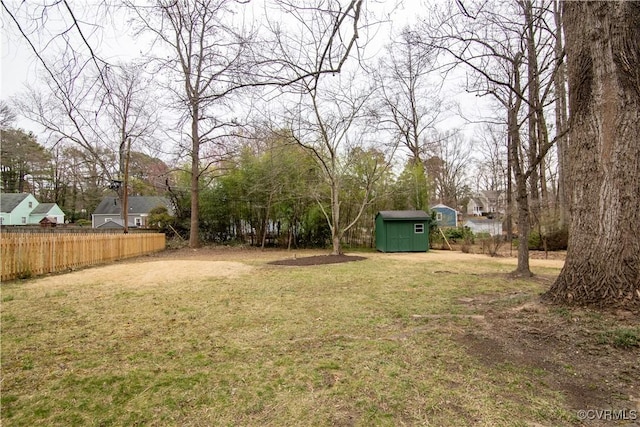 view of yard with an outbuilding, a shed, and fence